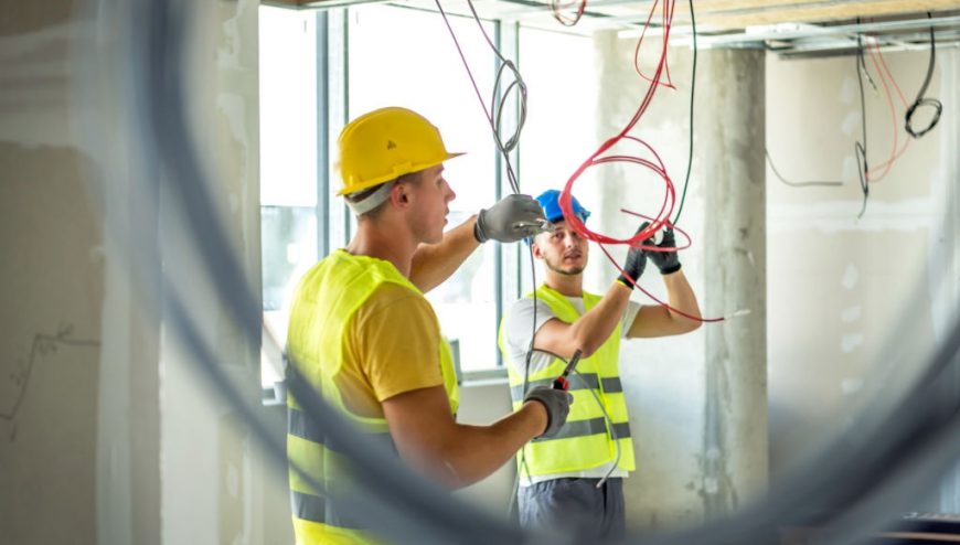 2 Electricians running electrical wire in a commercial building
